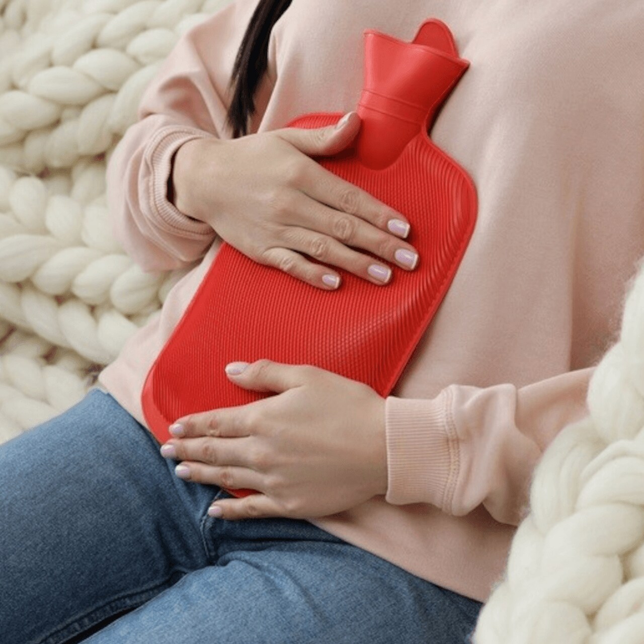Termofor gumowy 2l położony na brzuchu kobiety